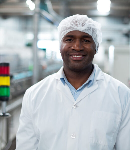 Smiling factory engineer standing in bottle factory Portrait of smiling factory engineer standing in bottle factory