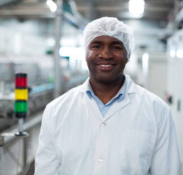 Smiling factory engineer standing in bottle factory Portrait of smiling factory engineer standing in bottle factory