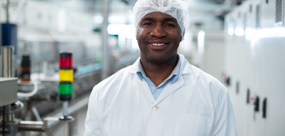 Smiling factory engineer standing in bottle factory Portrait of smiling factory engineer standing in bottle factory